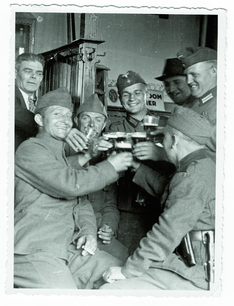 Na de gevechten in de meidagen proosten Nederlandse en Duitse soldaten breed lachend in een café. Afb.: WBooks Zwolle/Gerard Groeneveld